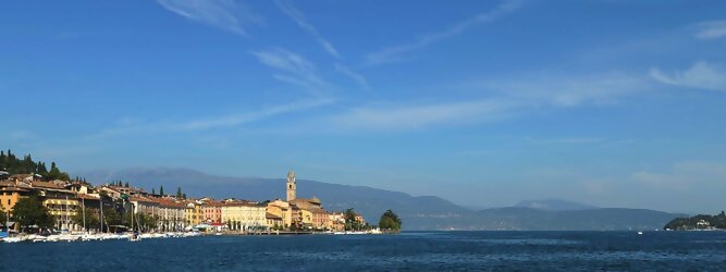 Fun beliebte Urlaubsziele am Gardasee -  Mit einer Fläche von 370 km² ist der Gardasee der größte See Italiens. Es liegt am Fuße der Alpen und erstreckt sich über drei Staaten: Lombardei, Venetien und Trentino. Die maximale Tiefe des Sees beträgt 346 m, er hat eine längliche Form und sein nördliches Ende ist sehr schmal. Dort ist der See von den Bergen der Gruppo di Baldo umgeben. Du trittst aus deinem gemütlichen Hotelzimmer und es begrüßt dich die warme italienische Sonne. Du blickst auf den atemberaubenden Gardasee, der in zahlreichen Blautönen schimmert - von tiefem Dunkelblau bis zu funkelndem Türkis. Majestätische Berge umgeben dich, während die Brise sanft deine Haut streichelt und der Duft von blühenden Zitronenbäumen deine Nase kitzelt. Du schlenderst die malerischen, engen Gassen entlang, vorbei an farbenfrohen, blumengeschmückten Häusern. Vereinzelt unterbricht das fröhliche Lachen der Einheimischen die friedvolle Stille. Du fühlst dich wie in einem Traum, der nicht enden will. Jeder Schritt führt dich zu neuen Entdeckungen und Abenteuern. Du probierst die köstliche italienische Küche mit ihren frischen Zutaten und verführerischen Aromen. Die Sonne geht langsam unter und taucht den Himmel in ein leuchtendes Orange-rot - ein spektakulärer Anblick.